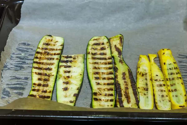 Gegrillte Zucchinischeiben auf einem Backblech