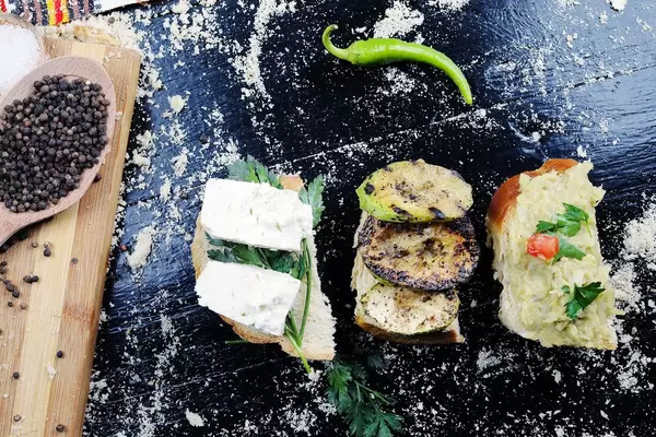 Gegrillte Zucchinischeiben mit Auberginensalat und Käse auf Weißbrot