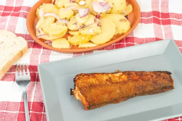 Gegrillter Seehecht mit Kartoffelsalat und einer Scheibe Brot