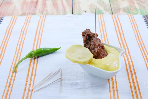 Gegrilltes Hackfleisch mit Kartoffelscheibe und Senf