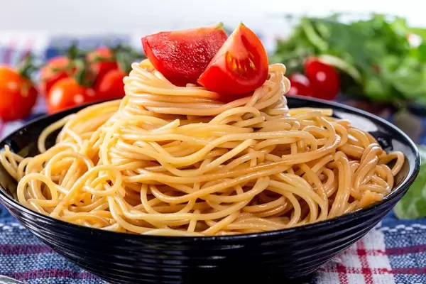 Gekochte Spaghetti in einer Schüssel mit Kräuter und frischem Gemüse