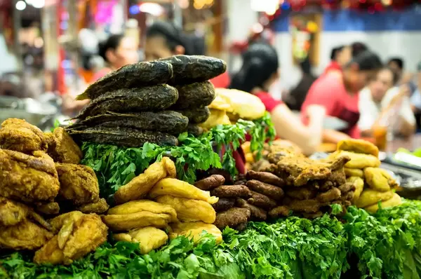 Gekochter Fisch, Hähnchen und Gemüse an einem Stand auf dem Markt