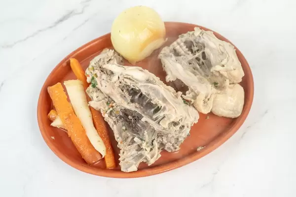 Gekochter Hühnchenrücken mit Möhren, Pastinaken und einer Zwiebel