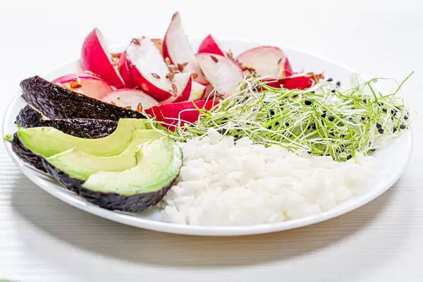 Gekochter weißer Reis mit Gemüse, Avocado und Mikrogreens