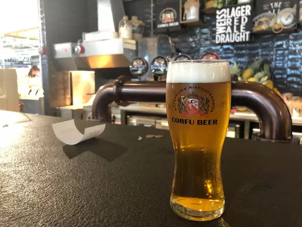 Gekühltes Korfu-Bier auf einem schwarzen Tresen einer griechischen Bar, im Flughafen Eleftherios Venizelos nahe Athen