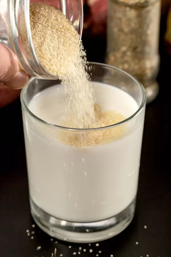 Gelatin is poured into milk, close-up