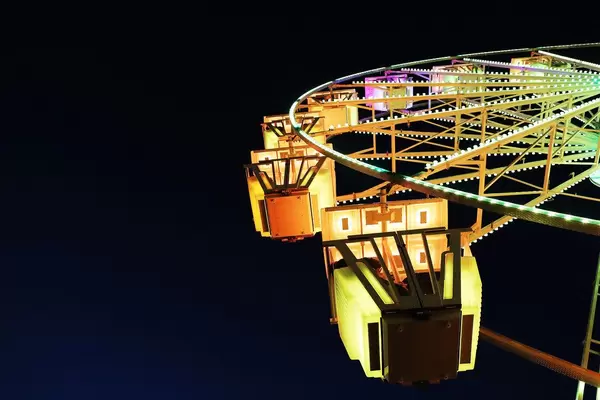 Gelb beleuchtetes Riesenrad von unten fotografiert