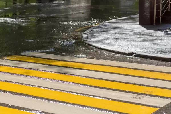 Gelb-weißer Zebrastreifen in Russland. Nasse Straße