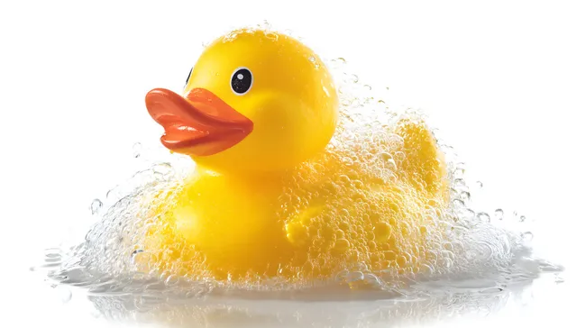 Gelbe Badeente in Wassersprudel auf Weiß