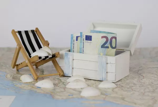 Geld in einer Truhe auf einer Landkarte. Urlaubsgeld