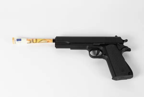 Geldschein ragt aus dem Lauf einer Pistole heraus. Gewalt ist profitabel