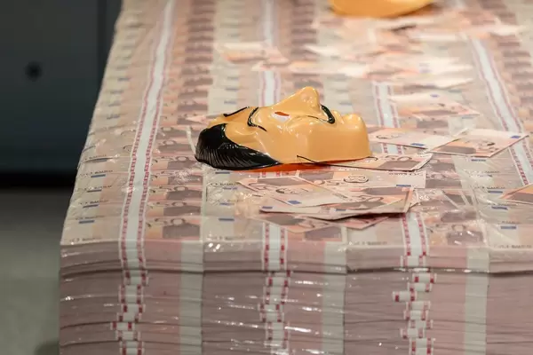 Geldstapel mit 50 Euro-Scheinen und der Salvador Dali Maske, bekannt von den Bankräubern aus Haus des Geldes von Netflix