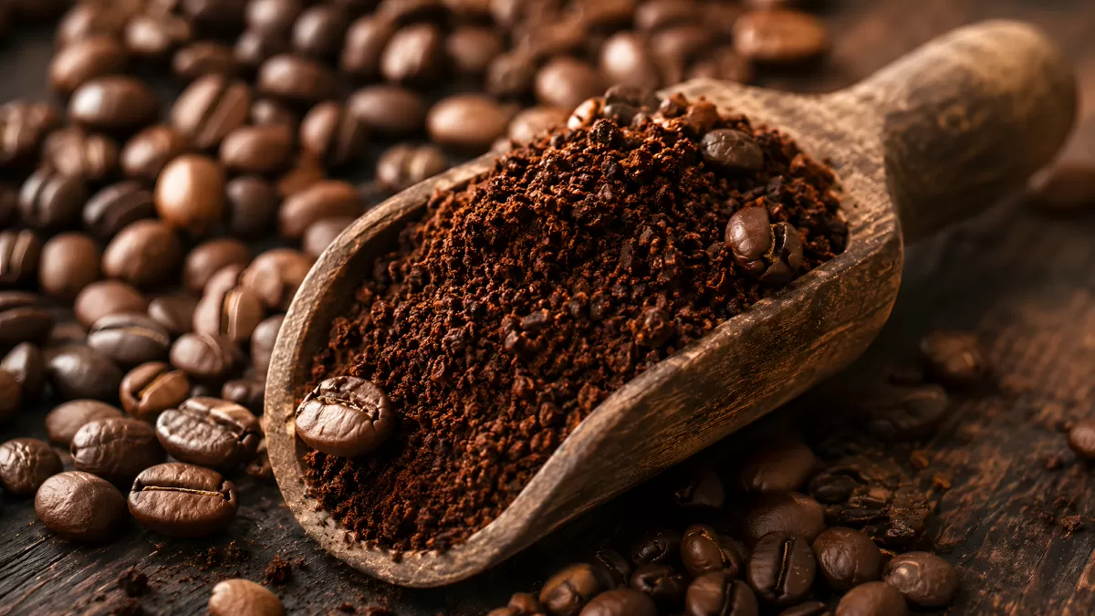Gemahlener Kaffee auf Holzschaufel mit Kaffeebohnen