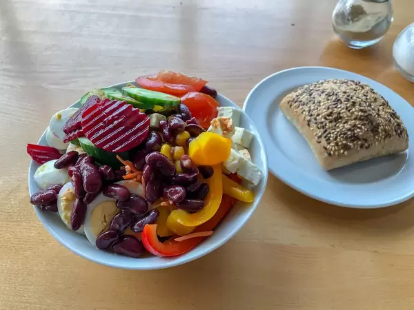 Gemischter Salat mit Bohnen, roter Bete, Paprika, gekochtem Ei, Tomaten, Käse und Vollkornbrötchen