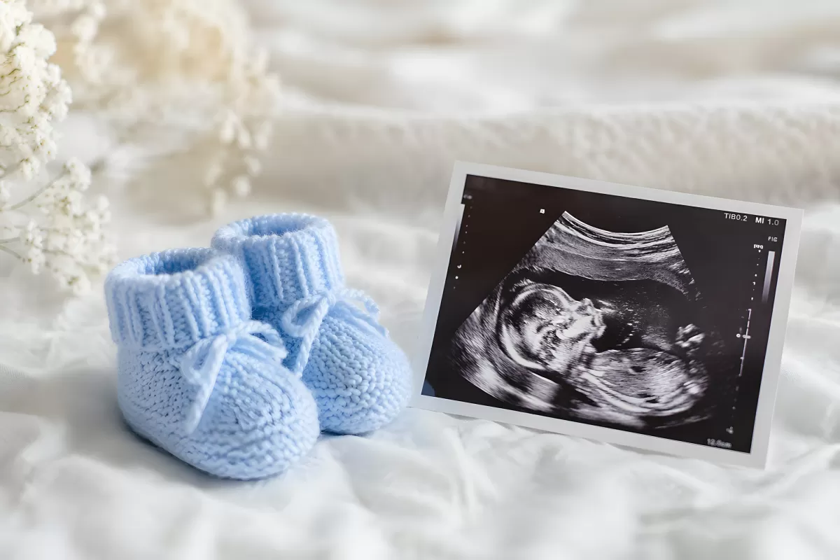 Gender Reveal: Blaue Babyschuhe und Ultraschallbild