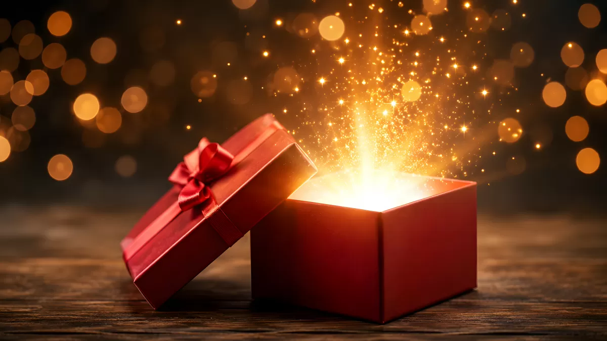 Geöffnete rote Geschenkbox mit goldenem Funkenregen