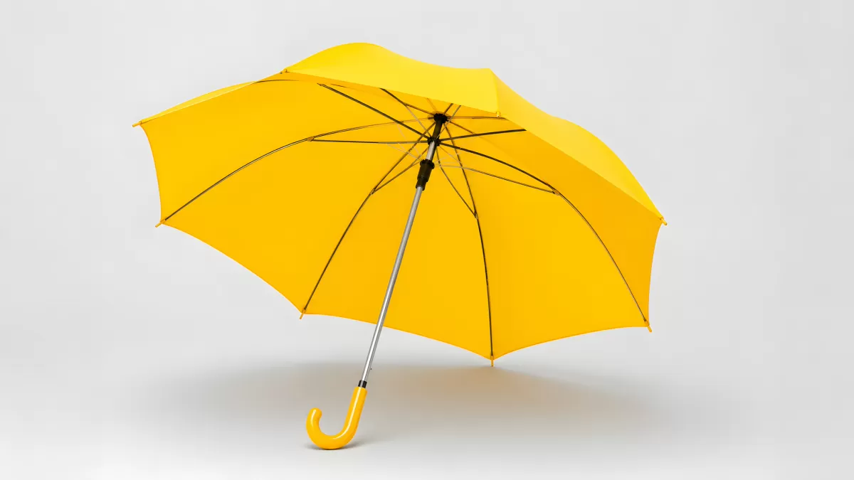 Geöffneter gelber Regenschirm vor hellem Hintergrund