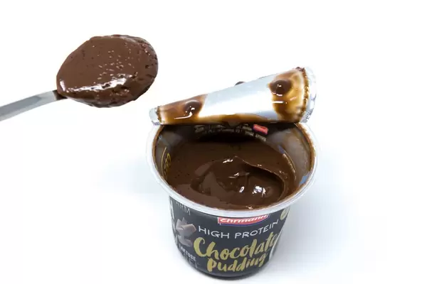 Geöffneter proteinreicher Schokoladenpudding von Ehrmann mit Löffel