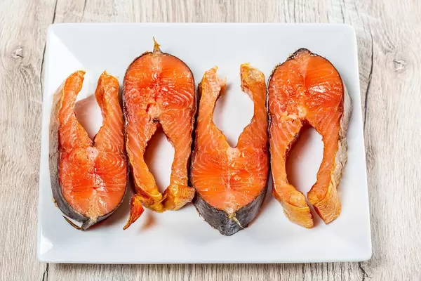 Geräucherte Lachssteaks auf weißem Teller in obene Aufnahme
