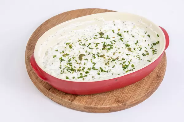 Geriebener Gurkensalat mit Zwiebeln, Sauerrahm und Kräutern