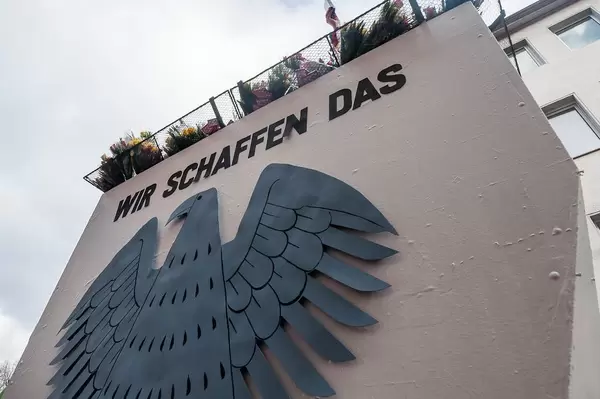German eagle with Merkel's quote about the migrant crisis "We can manage this"