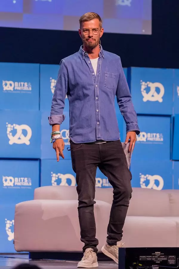 German presenter and actor Joko Winterscheidt standing on the stage at the founders' conference Bits & Pretzels 2019
