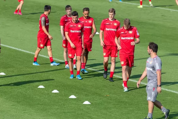 German soccer player and coach walking on the field after soccer training