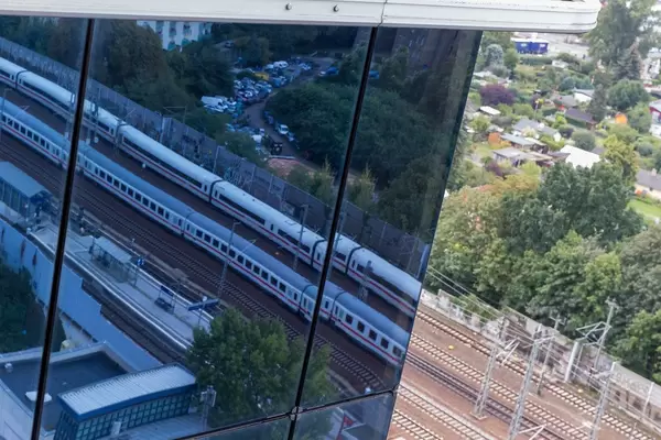German train on the tracks to Spandau train station and reflected image in the glass facade of Spiegel Tower in Berlin