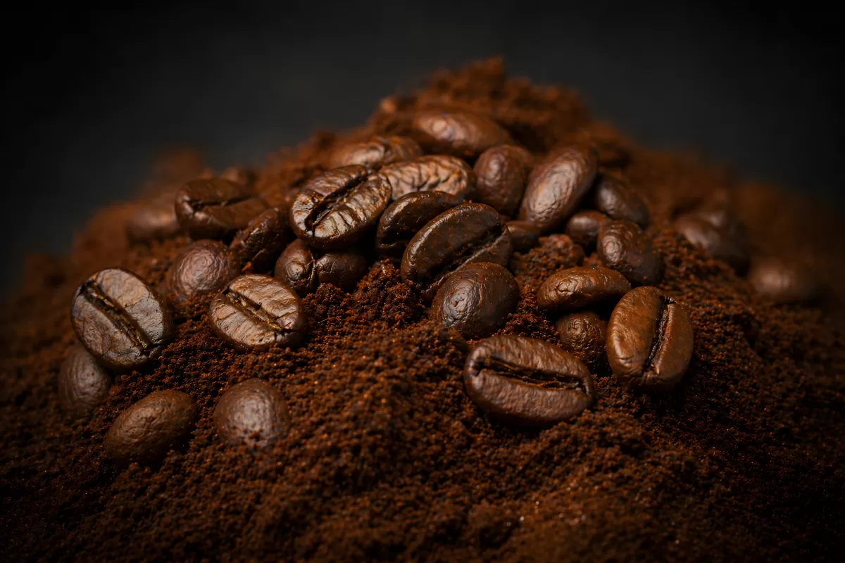 Geröstete Kaffeebohnen auf frisch gemahlenem Kaffee