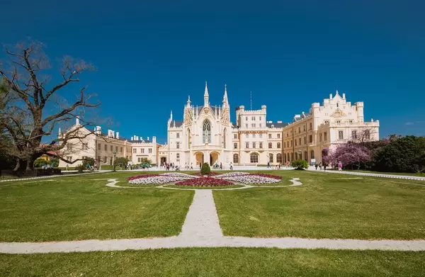 Gesamtansicht von Eisgrub-Schloss in Lednice, Tschechien, mit großem Garten und blauem Himmel