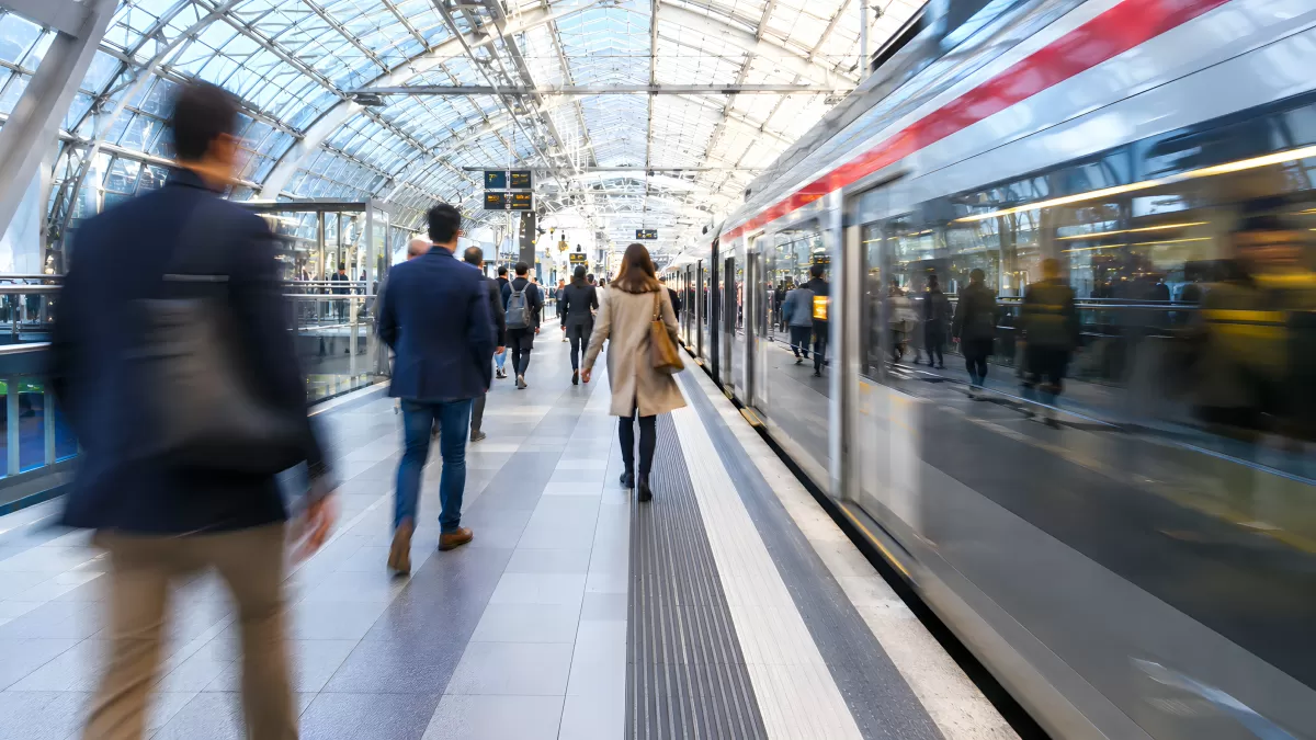 Geschäftige Bahnsteigszene mit Zug in modernem Bahnhof