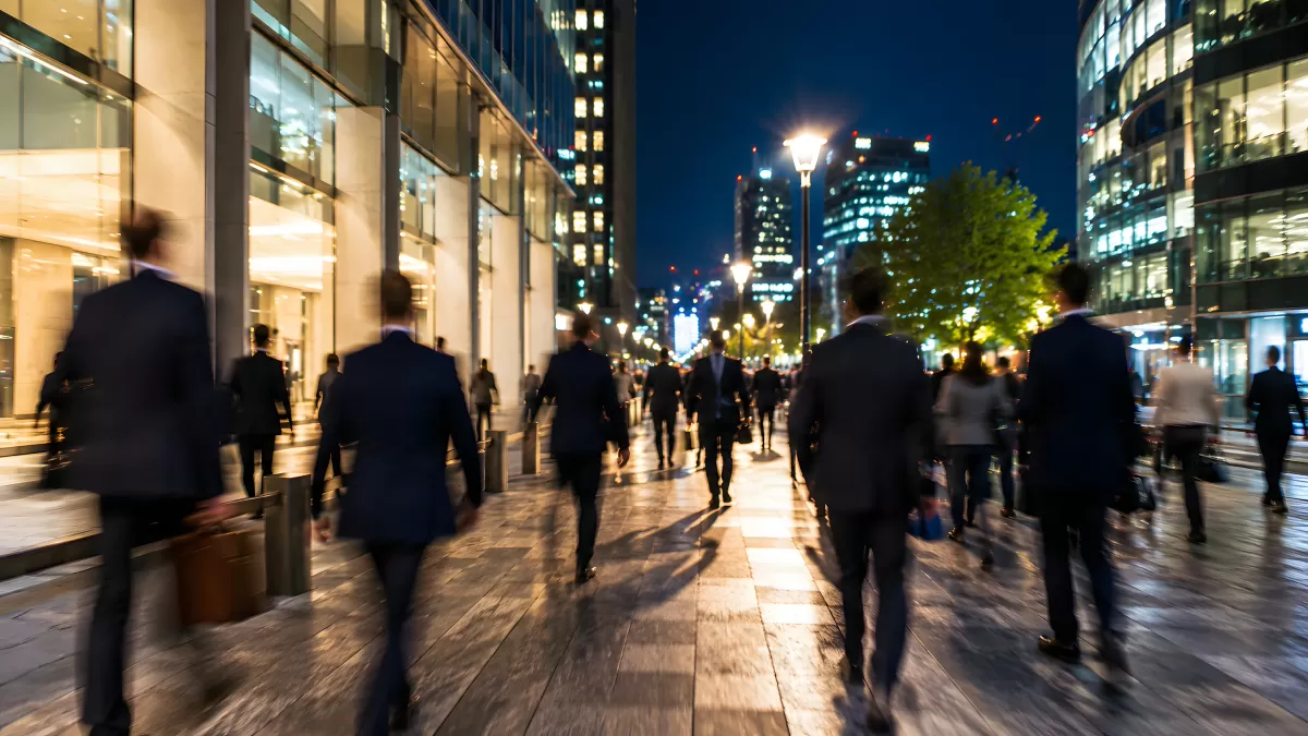 Geschäftsleute auf belebter Stadtpromenade bei Nacht