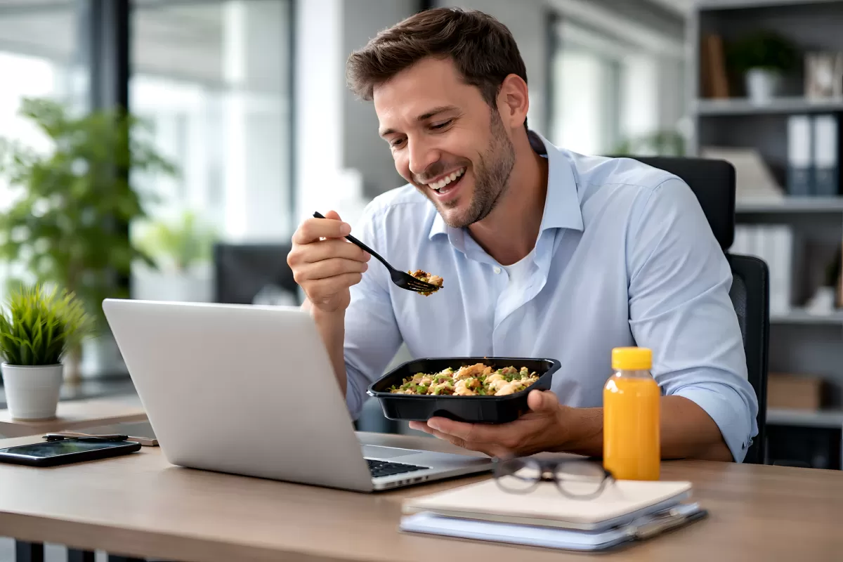 Geschäftsmann genießt gesunde Mahlzeit bei der Arbeit