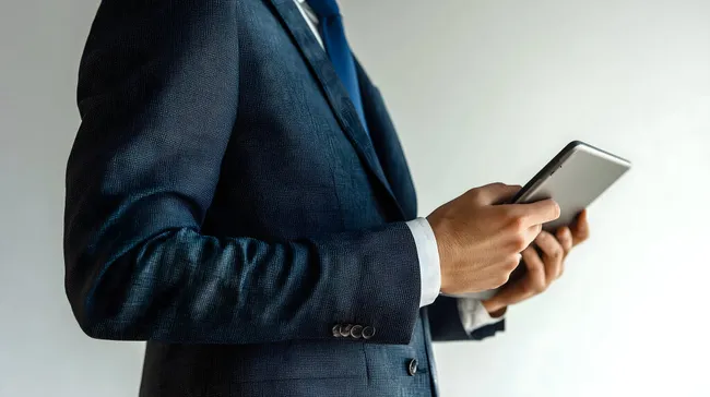 Geschäftsmann in elegantem Anzug mit Smartphone