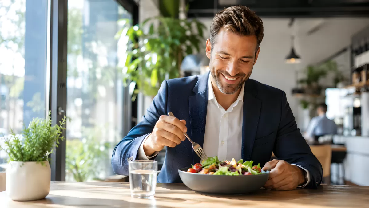 Geschäftsmann isst frischen Salat im modernen Café