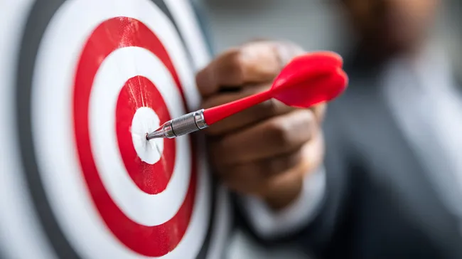 Geschäftsmann trifft Ziel mit Dartpfeil
