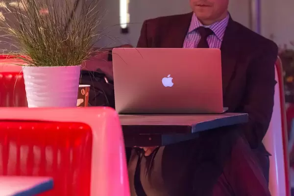 Geschäftsmann mit Anzug und Krawatte am MacBook Laptop
