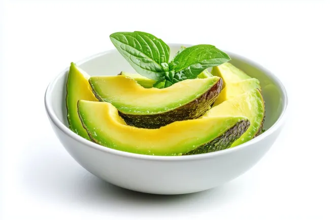 Geschnittene Avocado mit Basilikum in weißer Schale