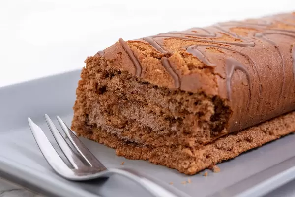 Geschnittene Schokokuchen-Rolle mit einer Gabel in der Nahaufnahme