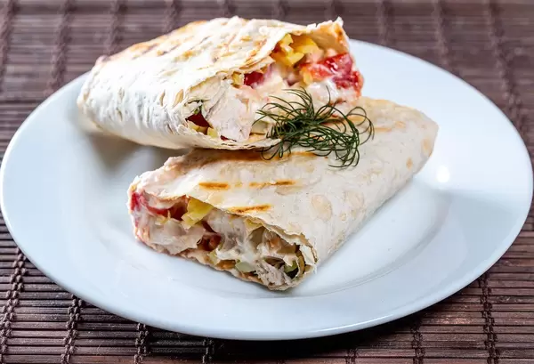 Geschnittene Shawarma mit knackigem Gemüse auf Teller auf Holz