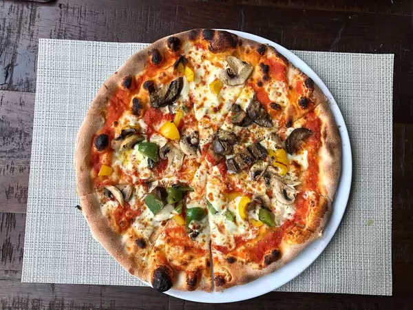 Geschnittene, vegetarische Pizza mit Gemüse und Pilzen, aus der Sicht von oben