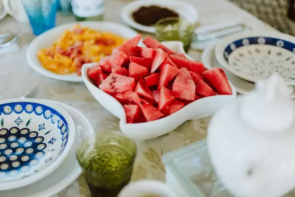 Geschnittene Wassermelonen in weißer Schale auf gedecktem Frühstückstisch