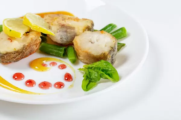 Geschnittener Fisch mit Gemüse und Mangosauce