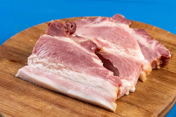 Geschnittener roher Speck auf dem hölzernen Brett