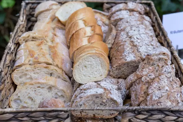 Geschnittenes Baguette in weiß und vollkorn in einem Korb an einem Buffet