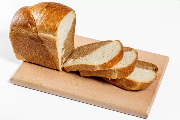 Geschnittenes Brot auf einem Schneidebrett mit weißem Hintergrund