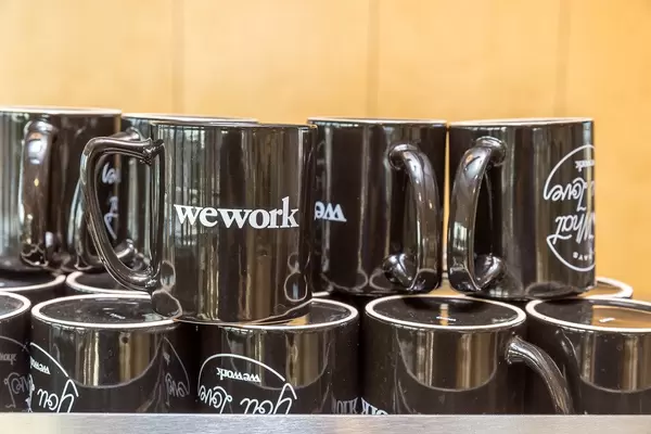 Gestapelte schwarze Tassen mit der Aufschrift "WeWork"