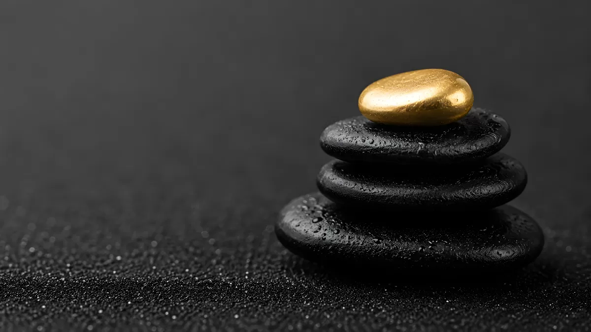 Gestapelte schwarze Zen-Steine mit goldenem Stein