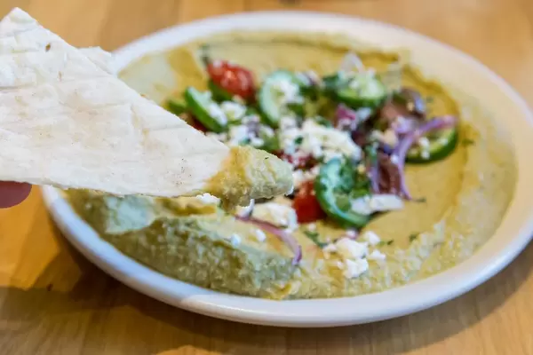 Gesund und saisonal essen bei True Food Kitchen in Chicago: Kräuter-Hummus mit Gurken, Bio-Tomaten, Oliven, Zwiebel, Feta, Zitrone- & Oregano-Vinaigrette & hausgemachtem Pita
