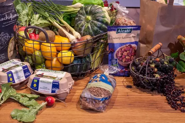 Gesunde Lebensmittel auf einem Holztisch: Obst, Gemüse, Studentenfutter, Eier